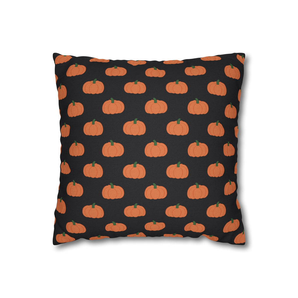 A square throw pillow featuring a repeating pattern of orange pumpkins with green stems on a black background.