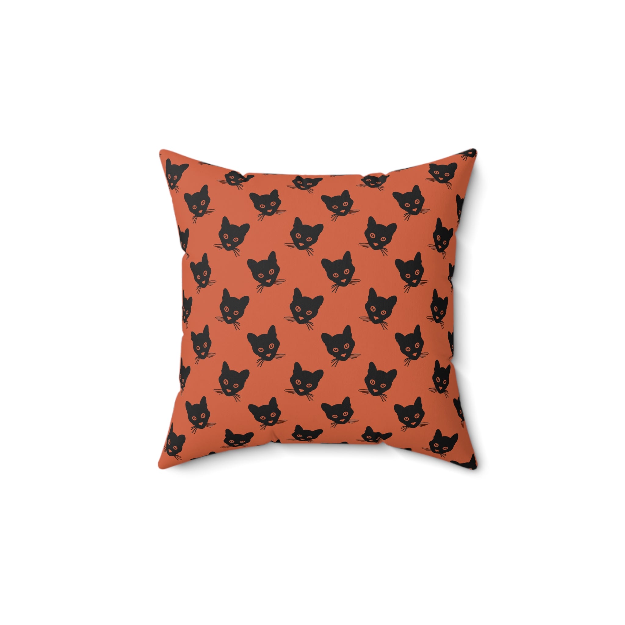 A square throw pillow with an orange background and a repeating black cat face pattern,.